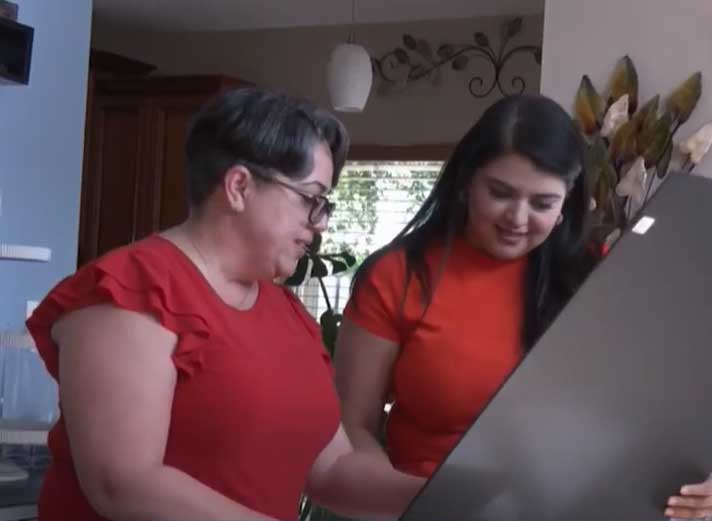 An adult woman looking at the image she drew when she was 10.