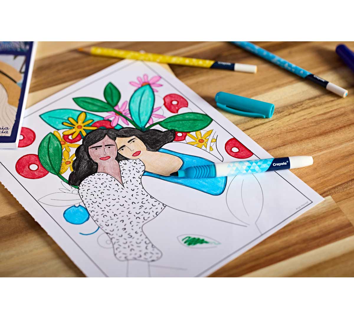 Artist Series Volume 1 Coloring Book. Partially colored select coloring page on tabletop surrounded by markers and pencils.